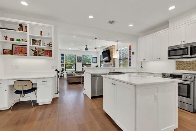 Kitchen with recessed lighting, stainless steel appliances, a peninsula, white cabinets, and open floor plan | Image 4