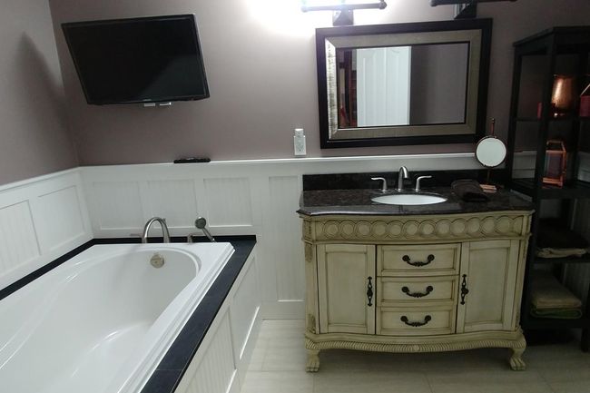 Bathroom with a bath, wainscoting, tile patterned flooring, and vanity | Image 12