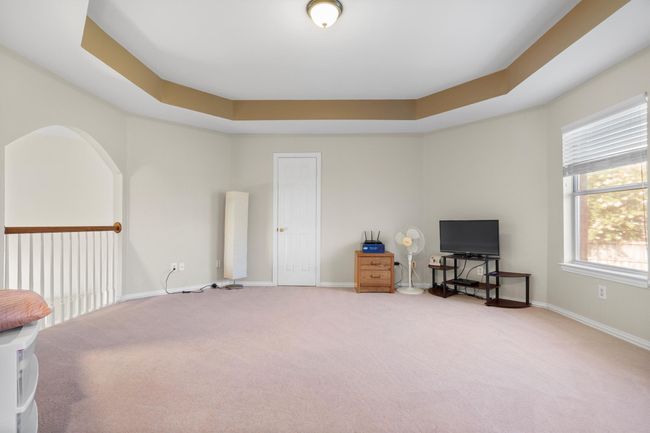 Living area with carpet flooring and a tray ceiling | Image 29