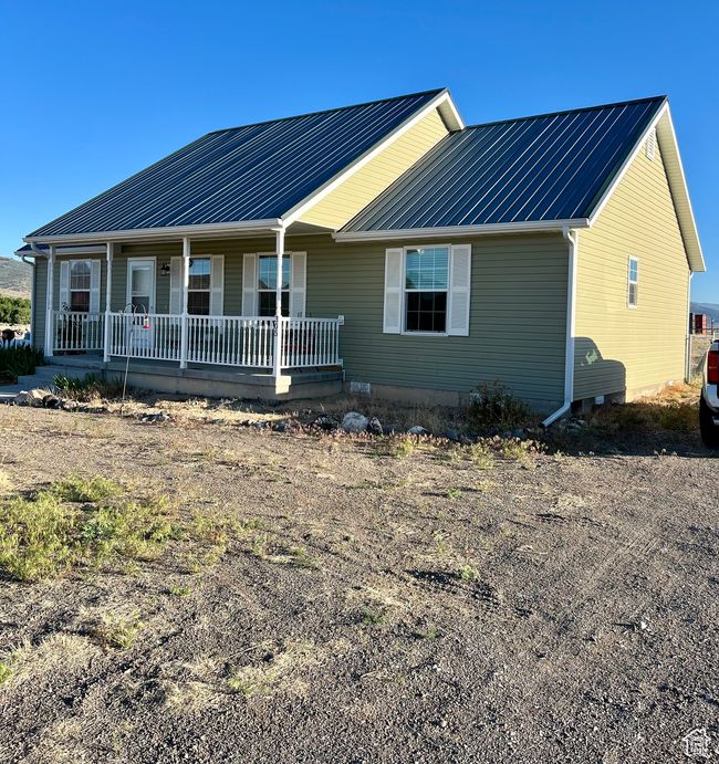 Single story home with a porch and a metal roof | Image 52