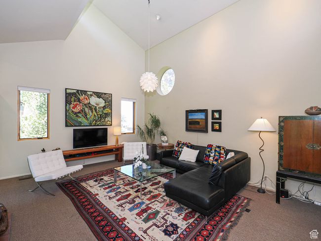 Carpeted living room featuring high vaulted ceiling | Image 9