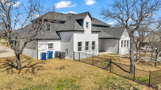 Rear view of property featuring brick siding, a shingled roof, a yard, and fence | Image 37