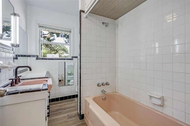 Full Bath off of the Primary Bedroom with tile backsplash, cast iron bathtub and vanity. | Image 7