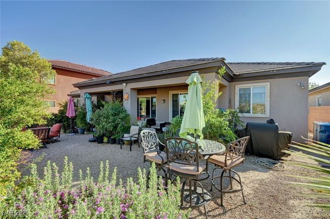 Rear view of house featuring a patio, stucco siding, and a tiled roof | Image 46
