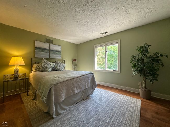 bedroom with wood finished floors, baseboards, and a textured ceiling | Image 30