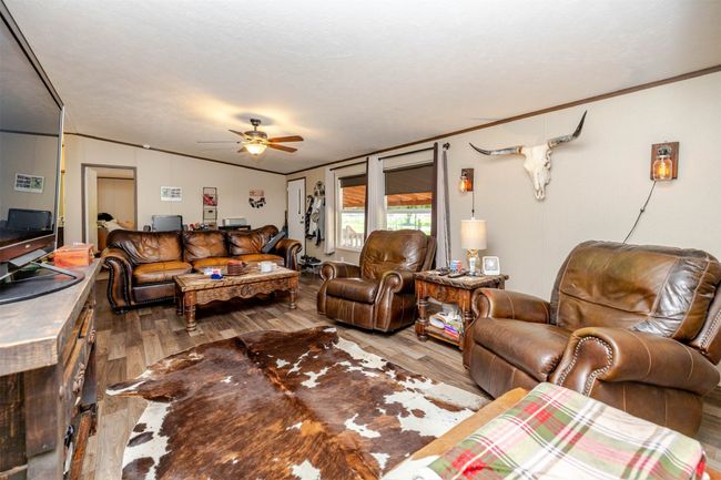 Living area featuring crown molding, wood finished floors, and a ceiling fan | Image 6