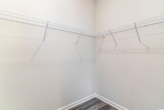 Spacious closet with dark wood-type flooring | Image 15
