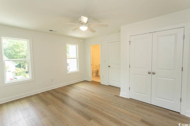 Unfurnished bedroom featuring baseboards, light wood-type flooring, connected bathroom, a closet, and ceiling fan | Image 19