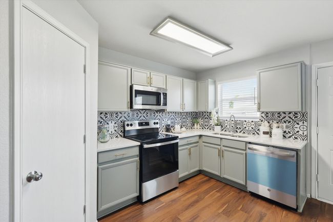 Kitchen featuring stainless steel appliances, gray cabinetry, and decorative backsplash | Image 13