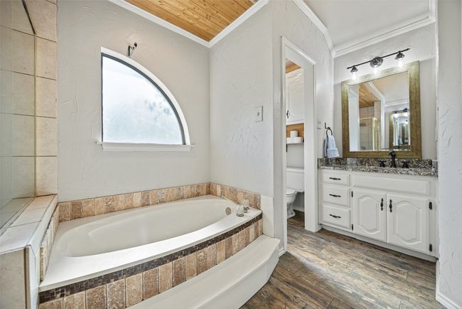 Full bathroom featuring crown molding, a bath, vanity, toilet, and wood finished floors | Image 19