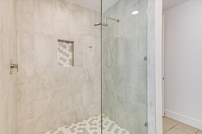 Bathroom featuring baseboards and tiled shower | Image 13