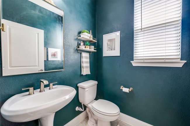 Bathroom with a sink, a textured wall, toilet, and baseboards | Image 25