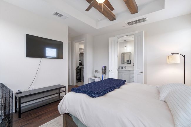 Bedroom featuring dark wood-style flooring, a walk in closet, beam ceiling, ensuite bathroom, and a closet | Image 28