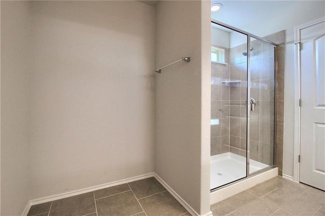 Bathroom featuring tile patterned floors, a stall shower, and baseboards | Image 28