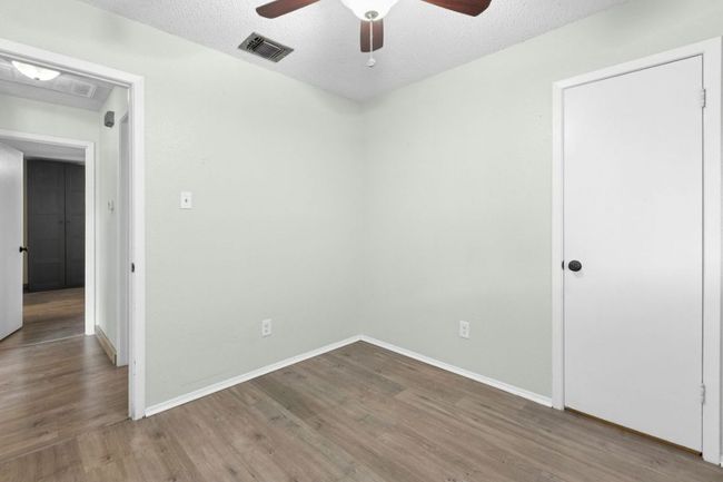 Spare room featuring dark wood finished floors, a textured ceiling, and a ceiling fan | Image 18