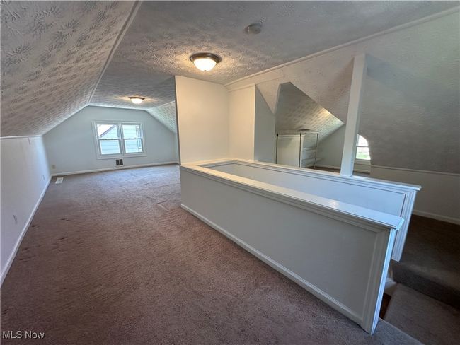 Additional living space featuring lofted ceiling, carpet, baseboards, and a textured ceiling | Image 27