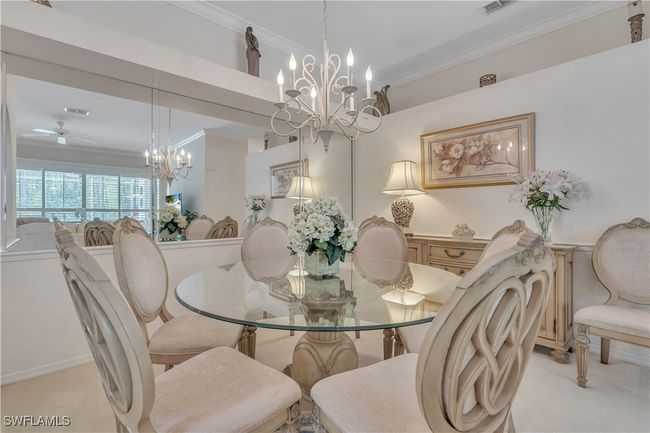 Carpeted dining space with a chandelier, ornamental molding, and ceiling fan | Image 6