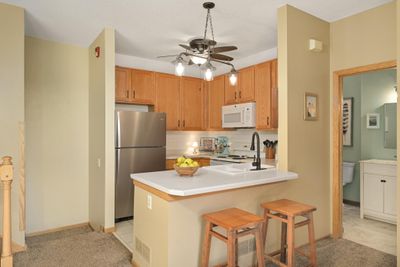 Fantastic kitchen with oak cabinets, updated hardware & tile backsplash. Convenient snack bar seating. | Image 2