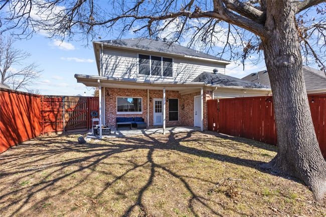 Back of property with a gate, brick siding, a fenced backyard, and a patio area | Image 18