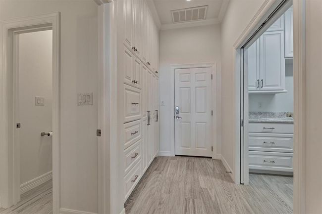 Every inch of this home was thoughtfully utilized, including the hallway off the garage. Custom cabinets and drawers provide discreet storage for mudroom essentials, keeping the space organized and clutter-free while maintaining a polished look. | Image 31