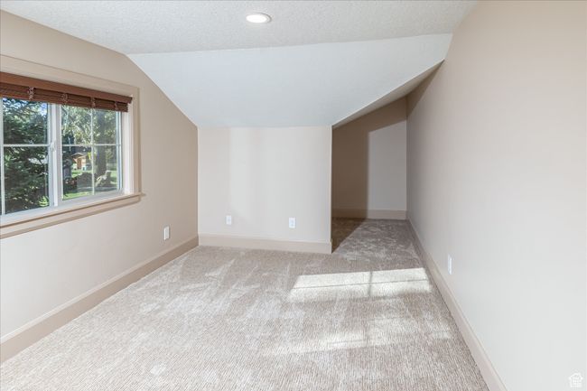 Bonus room featuring lofted ceiling, carpet flooring, a textured ceiling, and recessed lighting | Image 38