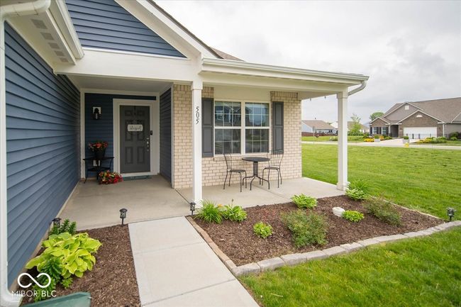 property entrance with a porch, brick siding, and a yard | Image 6