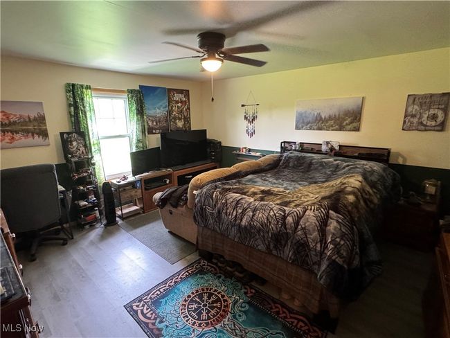 Bedroom with wood finished floors and a ceiling fan | Image 14