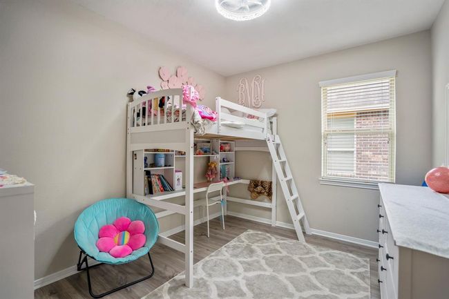 The fourth bedroom boasts vinyl plank floors and a lovely window that lets in plenty of natural light, creating a bright and inviting space. | Image 30