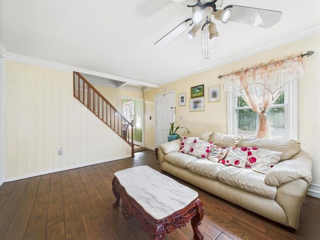 Living room featuring wood-type flooring, stairs, and ceiling fan | Image 8