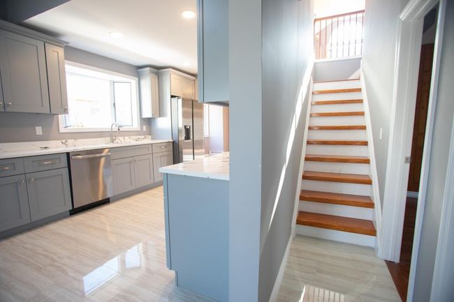 Kitchen featuring gray cabinetry, light stone countertops, and appliances with stainless steel finishes | Image 25