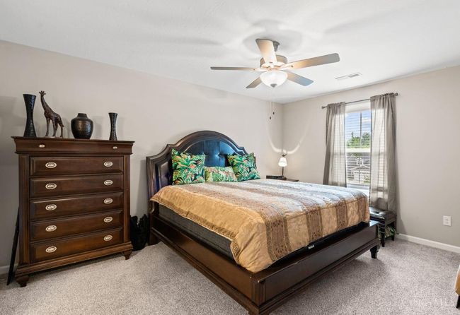 Primary bedroom with ceiling fan, natural light, large walk in closet and in suite full bath. | Image 21
