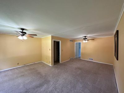 Carpeted spare room with ornamental molding and ceiling fan | Image 2