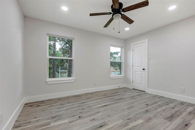 Secondary bedroom #1 with walk in closet, Vinyl flooring, ceiling fan and recess light. | Image 31