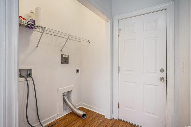 Laundry area with wood finished floors and hookup for a washing machine | Image 7