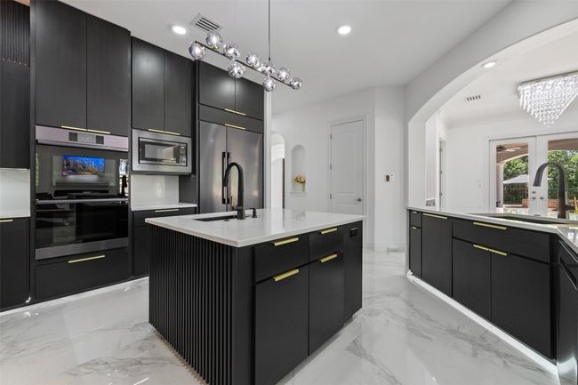 Kitchen with arched walkways, a sink, appliances with stainless steel finishes, modern cabinets, and recessed lighting | Image 11