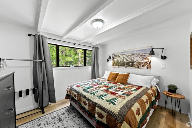 Bedroom featuring beam ceiling, baseboards, and light wood finished floors | Image 9
