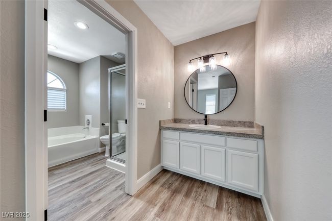 Bathroom featuring a bath, vanity, wood finished floors, and a shower with shower door | Image 20