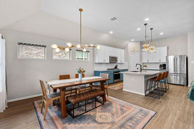 Dining area featuring a chandelier, wood finished floors, recessed lighting, lofted ceiling, and baseboards | Image 4