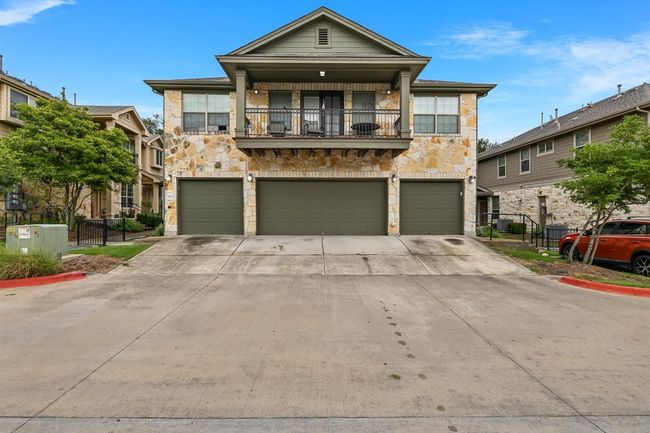 View of front facade featuring stone siding, a balcony, and a garage | Image 19