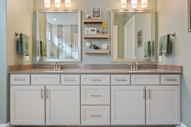 Primary Bathroom with double vanity, framed mirrors, upgraded cabinetry with plenty of drawers, and a walk in shower | Image 19