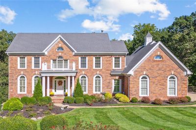 Colonial-style house with a balcony and a front lawn | Image 1