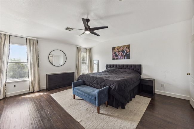 Bedroom featuring dark wood-style floors, baseboards, and visible vents | Image 17