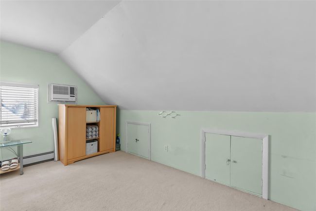 Bonus room with a baseboard heating unit, vaulted ceiling, an AC wall unit, and light carpet | Image 20