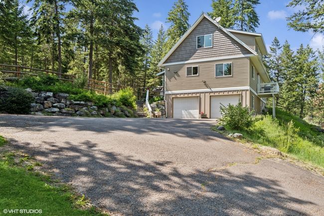 View of side of property featuring asphalt driveway and a garage | Image 51