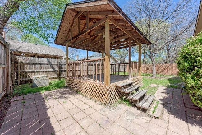 View of patio with a deck and a fenced backyard | Image 27