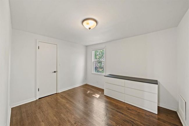 Spare room featuring baseboards and wood finished floors | Image 18