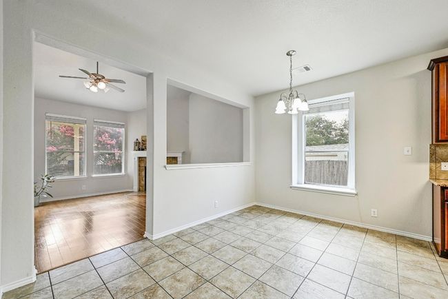 Empty room with a chandelier, light tile patterned flooring, and a ceiling fan | Image 10