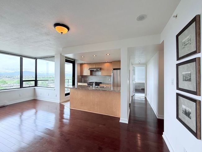Kitchen featuring freestanding refrigerator, modern cabinets, dark wood-style floors, under cabinet range hood, and decorative backsplash | Image 11