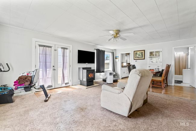 Carpeted living room with french doors and ceiling fan | Image 5
