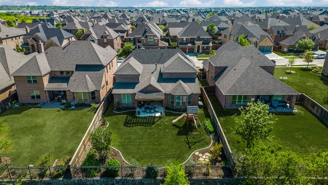 Stunning aerial view of this spacious yard with professional landscaping and large covered back patio. | Image 35